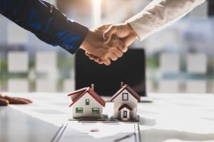 Buyers review inspection papers and closing documents at a table inside a bright home.
