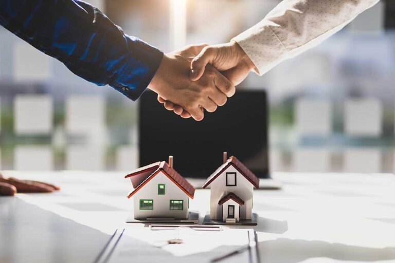 Buyers review inspection papers and closing documents at a table inside a bright home.